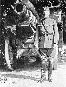 General Clarence Edwards standing next to an artillery piece