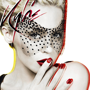 An image of Minogue posing with a fishnet veil. She wears bold red lipstick and nail polish, with her right hand slightly covering her lips.