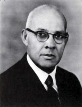 Black and white photograph of Davis in his older age, dressed in a suit and tie, and wearing eyeglasses