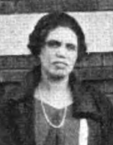 An African-American woman wearing a dark jacket and beads