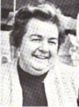 A smiling middle-aged white woman with short dark hair