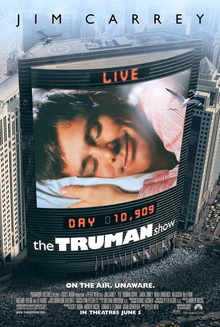 Film poster. On the side of the building is a large screen, showing a man laying his head on a pillow, eyes closed and smiling. Digital text above and below the screen state "LIVE" and "DAY 10,909", with the film's title right below it. Text at the top of the image includes the sole starring credit and text at the bottom includes the film's tagline and credits.