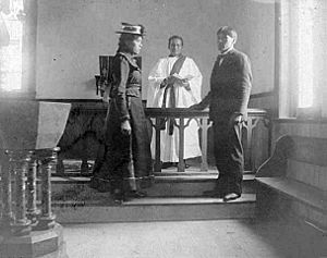 Native American boarding school-Young woman and young man standing at a church altar with a priest