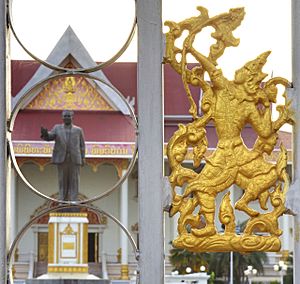 View of Kaysone Phomvihane Museum showing Sinxay figure in front gate with statue of Kaysone in the background