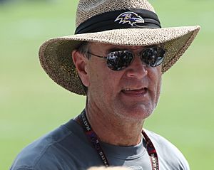 Billick wearing sunglasses and a wide-brimmed straw hat with a Ravens logo on the hatband