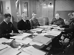 Winston Churchill and his Chiefs of Staff around a conference table aboard SS QUEEN MARY en route to the USA, May 1943. A16709