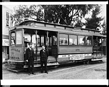 External view of a Plaza University trolley car of the Los Angeles Railway Company, showing two conductors posed in front, ca.1900-1910 (CHS-33085)