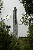 A tall, octagonal white and black lighthouse