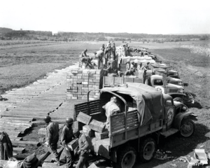 Soldiers load trucks with combat rations in preparation for a convoy to the front line