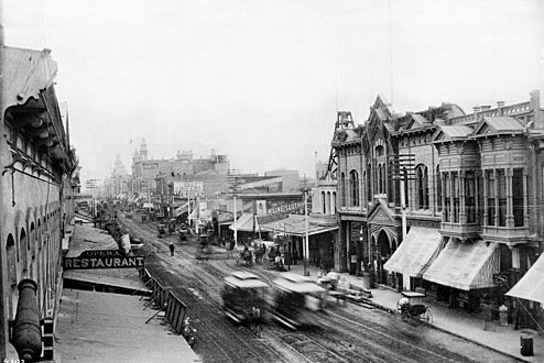 Two horsecars pass each other in a blur on Main Street between First and Second streets, circa 1889