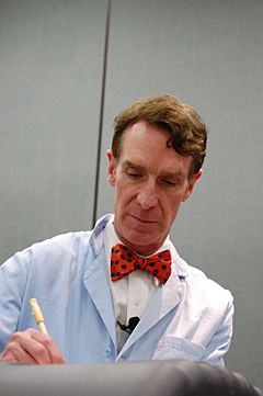 Bill Nye with trademark blue lab coat and bowtie