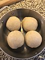 four dumplings in a round baking dish.