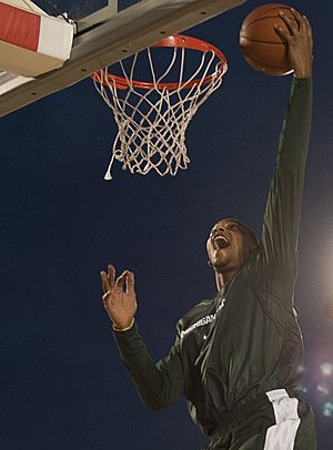 US Navy 111110-N-DR144-711 Michigan State University basketball player Adreian Payne dunks during a practice in the basketball arena on the flight (cropped).jpg