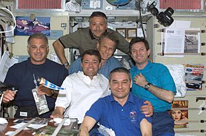 STS-112 and Expedition 5 crew share a meal