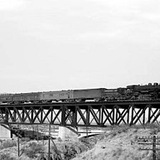 Sunset Limited of the Southern Pacific Railroad being pulled over the old El Paso and Southwestern Railroad bridge with Ciénega Bridge (then part of the Dixie Overland Highway) in the background. The photograph was taken in 1921 when the bridge was brand new.