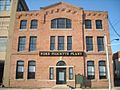 alt=A large brick building with a sign that says Ford Piquette Plant
