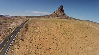 Aerial view of Agathla peak with Monument Valley road (163) in the foreground