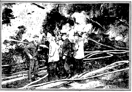 Los Angeles City firemen talk amid tangled hoses at spectacular fire in 1921