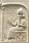 Representation of Shamash from the Tablet of Shamash (c. 888 – 855 BC), showing him sitting on his throne dispensing justice while clutching a rod-and-ring symbol