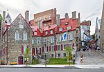 Old town with houses built in stone and several flags of Quebec