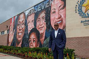 Ellis stands in front of a mural honoring Supreme Court Justice Ketanji Brown Jackson