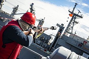 Navy Petty Officer fires a line to the USNS Supply in the Baltic Sea