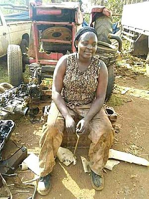 An african lady working at a garage. She is a mechanic
