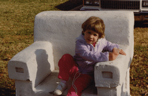Girl sitting in Monte Ne chair at Frisco Park, 1987
