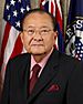 Head and shoulders portrait of an older Asian man wearing a business suit and tie.