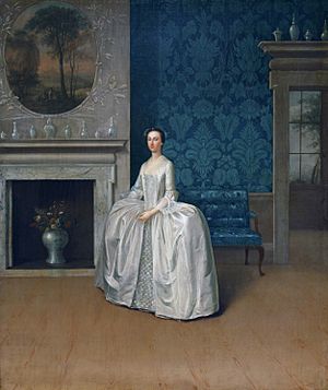 A formal full-length portrait of a young woman standing in a blue room
