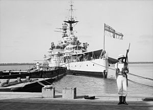 Haifa, result of terrorist acts & government measures. H.M.S. Repulse taken from the docks, marine on guard below British flag.1938