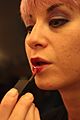 Applying red lipstick - model Eve Casini