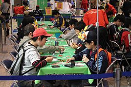 Children (hands holding cards) competing at a Pokémon TCG junior tournament