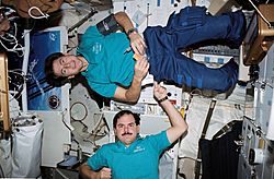 STS035-49-028 - STS-35 payload specialists perform balancing act on OV-102's middeck - 1990