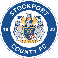 The words "Stockport County FC" in a circle (along with "18 on the left and "83" on the right) surround the main crest consisting of a shield featuring a hat and castle on top along with two lions rampant either side.