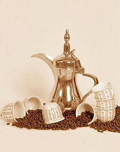 A dallah a traditional Arabic coffee pot with cups and coffee beans.jpg