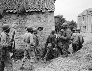 A platoon of Negro troops surrounds a farm house in a town in France, as they prepare to eliminate a German sniper... - NARA - 531188