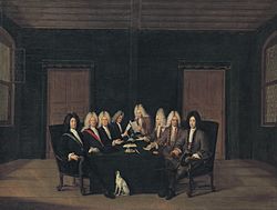 A painting showing eight bewigged men, sat around a table with papers and quills