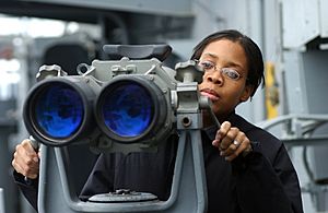 US Navy 021206-N-1328C-501 Signalman 3rd Class Tiffany Culereth from Bronx, N.Y., observes ships in the area through binoculars called ^ldquo,Big Eyes.^rdquo,