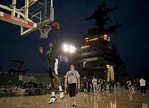 US Navy 111110-N-DR144-711 Michigan State University basketball player Adreian Payne dunks during a practice in the basketball arena on the flight