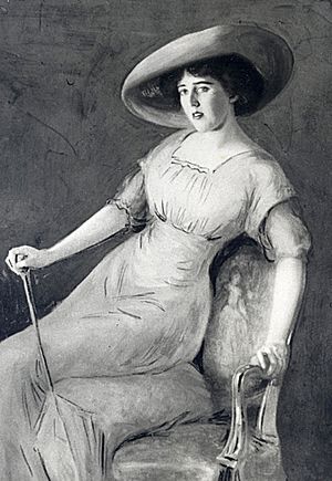 Painting of a dark-haired woman of about 30 posing on the edge of an upholstered chair with the help of a decorative walking stick. She wears an elegant full-length gown and a wide-brimmed hat.