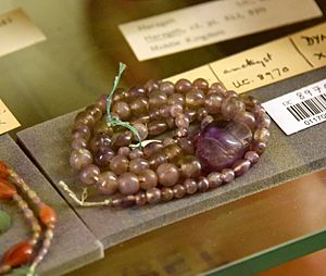 Uninscribed amethyst scarab at the center of a string of amethyst ball beads. Middle Kingdom. From Egypt. The Petrie Museum of Egyptian Archaeology, London