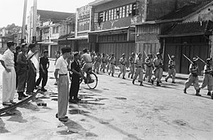 Een afdeling TNI militairen marcheert door een lege straat. Aan de zijkant kijke, Bestanddeelnr 889