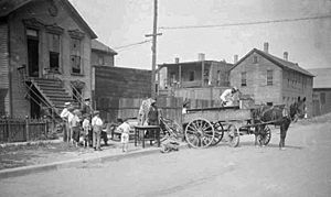 Chicago race riot, three African American men moving furniture while young Caucasian boys watch