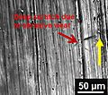 Deep 'groove' like surface indicates abrasive wear over cast iron (yellow arrow indicate sliding direction)