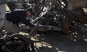 NTSB highway investigator Michael Fox examines mangled truck involved in CA grade crossing accident. (16652006442)