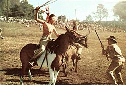 A young boy on horseback, recreating the Indian Raid during the Flax Scutching Festival