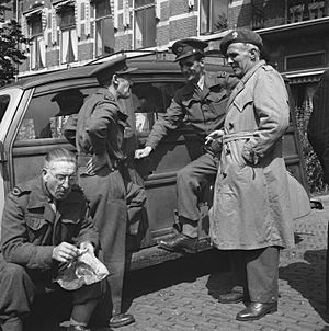 Militairen bij de ingang van het Elisabeth Gasthuis te Arnhem. Drie dragen het i, Bestanddeelnr 900-6665