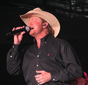 Country music singer Tracy Lawrence, singing into a microphone.