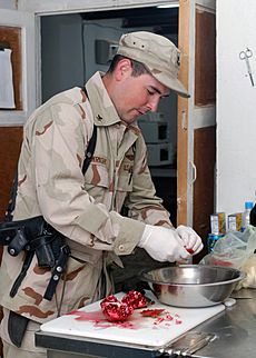 US Navy 071030-N-7415V-007 Culinary Specialist 2nd Class Timothy Wright, assigned to the Combined Security Transition Command-Afghanistan, cuts up pomegranates to put out as a snack